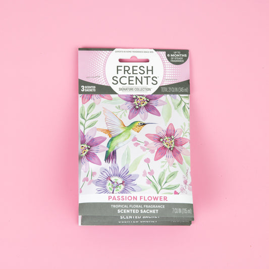 Fresh Scents Passion Flower - Sachet 3pk adds long-lasting, flameless fragrance with a floral and hummingbird design on a pink background.