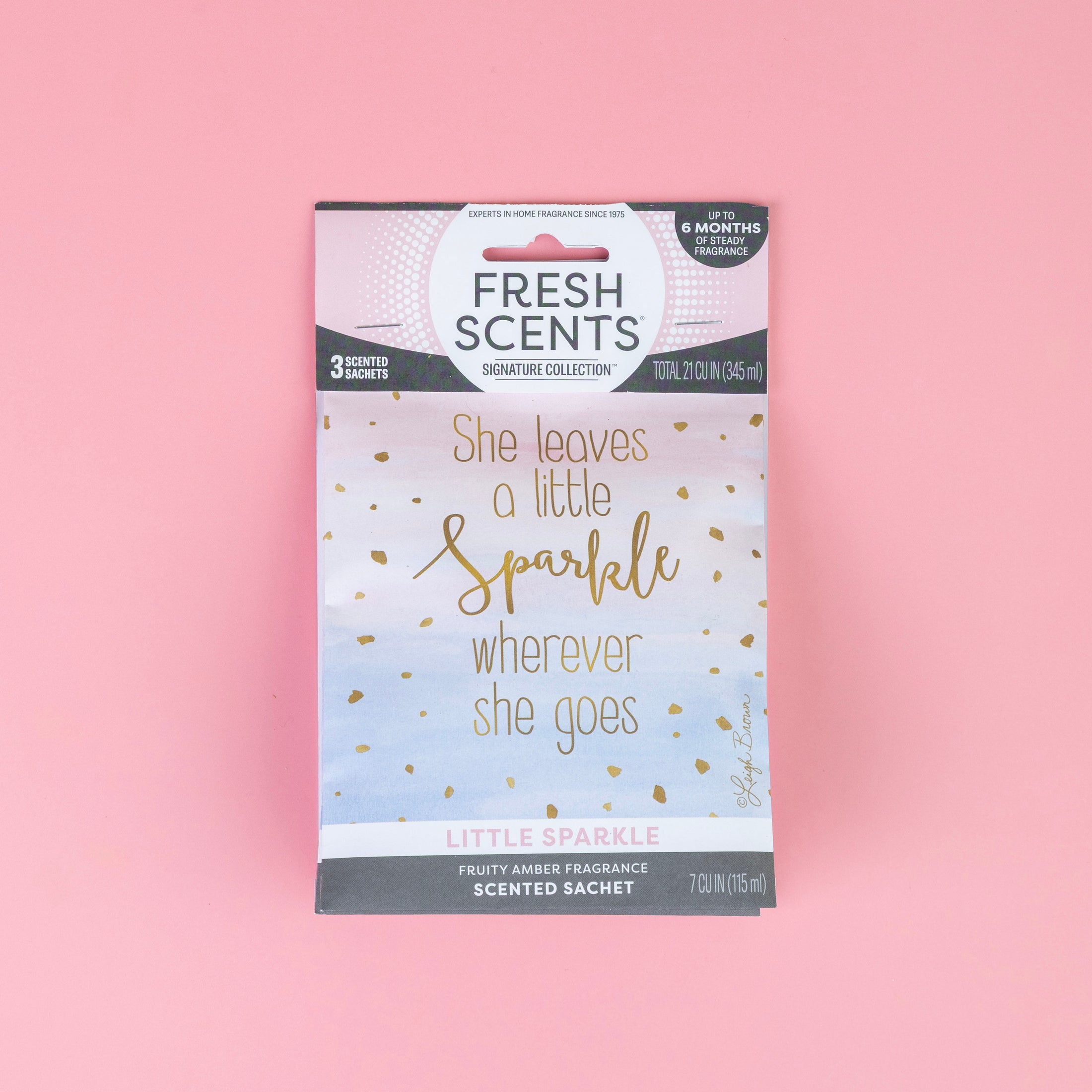 A Fresh Scents Little Sparkle - Sachet 3pk is shown on a pink background. This fruity amber flameless air freshener features "She leaves a little sparkle wherever she goes" and offers long-lasting fragrance.