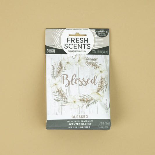 Fresh Scents Blessed Wreath 3pk sachets feature a floral wreath on a light wood background with “Blessed” scripted at the center. Enjoy long-lasting, flameless fragrance in any space.