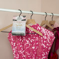 Load image into Gallery viewer, A bright pink sequin dress hangs on a rack with a Fresh Scents Little Sparkle - Sachet 3pk, adding long-lasting fragrance with the message "She leaves a little sparkle wherever she goes." More pink dresses hang in the background.
