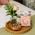 Load image into Gallery viewer, A wicker tray on a bed holds a cinnamon roll, coffee mug, small vase with a rose and greenery, and a Fresh Scents Summer Romance Sachet 3pk—a flameless fragrance for subtle, long-lasting freshness.
