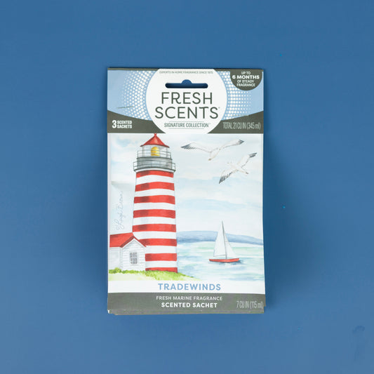 The Fresh Scents Tradewinds - Sachet 3pk features a red and white lighthouse, seagulls, a sailboat, and ocean art. Enjoy this flameless air freshener for long-lasting fragrance anywhere.