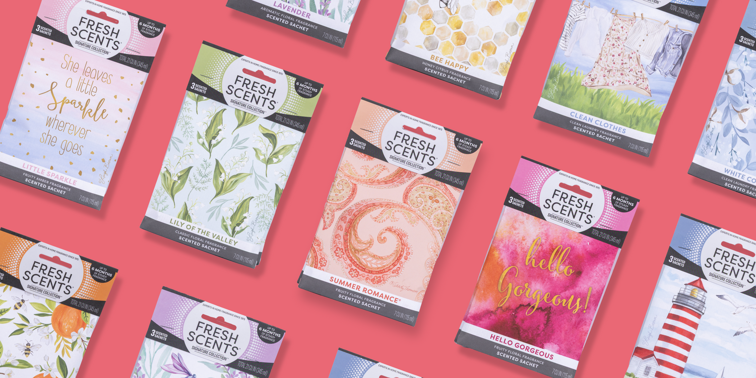 Assorted Fresh Scents scented sachet packets with colorful designs are arranged diagonally on a pink background. The visible scents include Lavender, Lily of the Valley, Summer Romance, and Hello Gorgeous.
